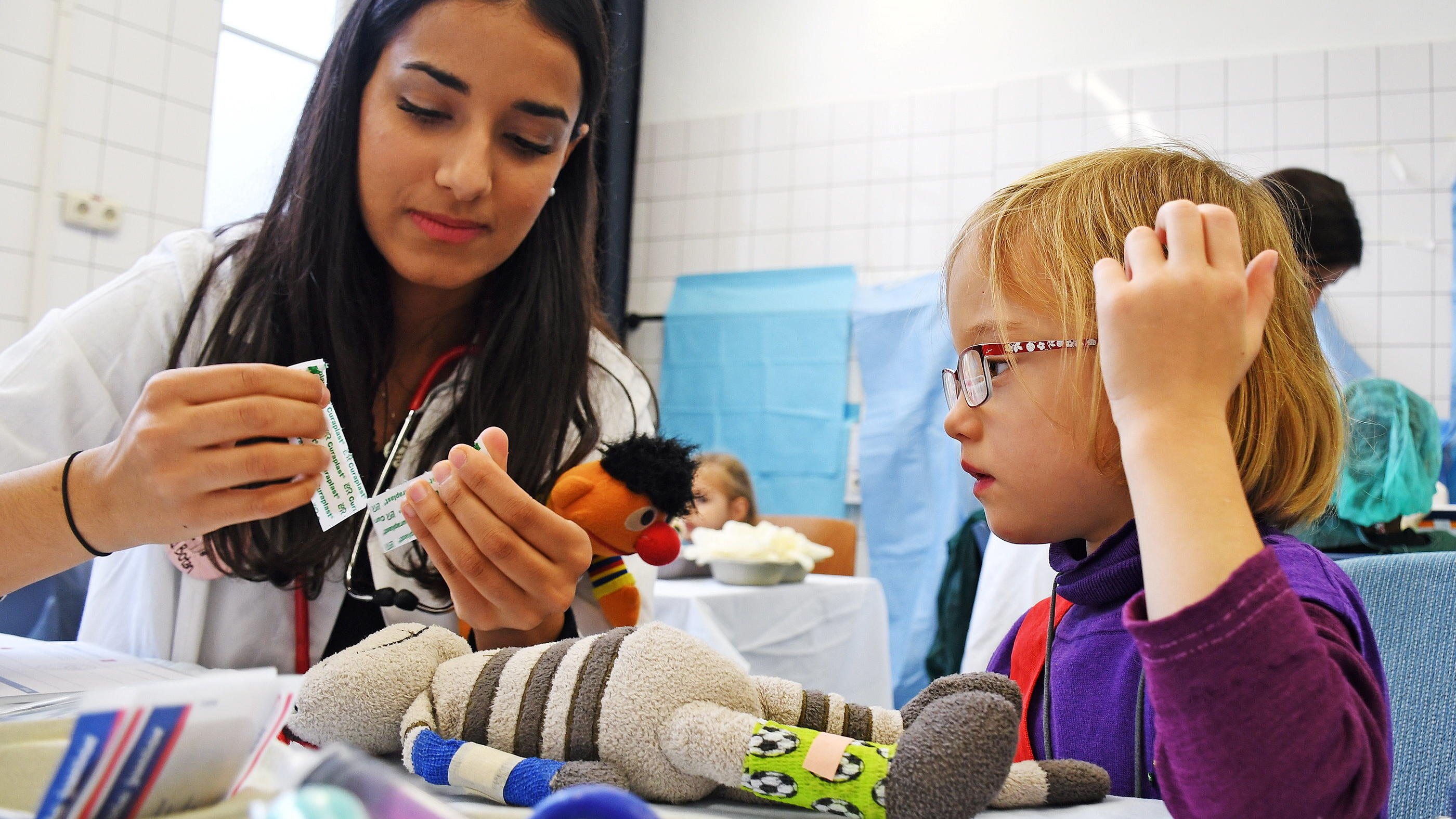 Oh, Schreck! Babys Lieblingsteil ist weg! 10.10.2019, Rheinland-Pfalz, Mainz: Die Mitarbeiterin Helanin der Teddyklinik im Skills Lab der Universitätsmedizin Mainz verarztet zusammen mit der fünfjährigen Katharina das Kuscheltier Katzi. Das dreitägige Angebot soll Kindern die Angst vor einem