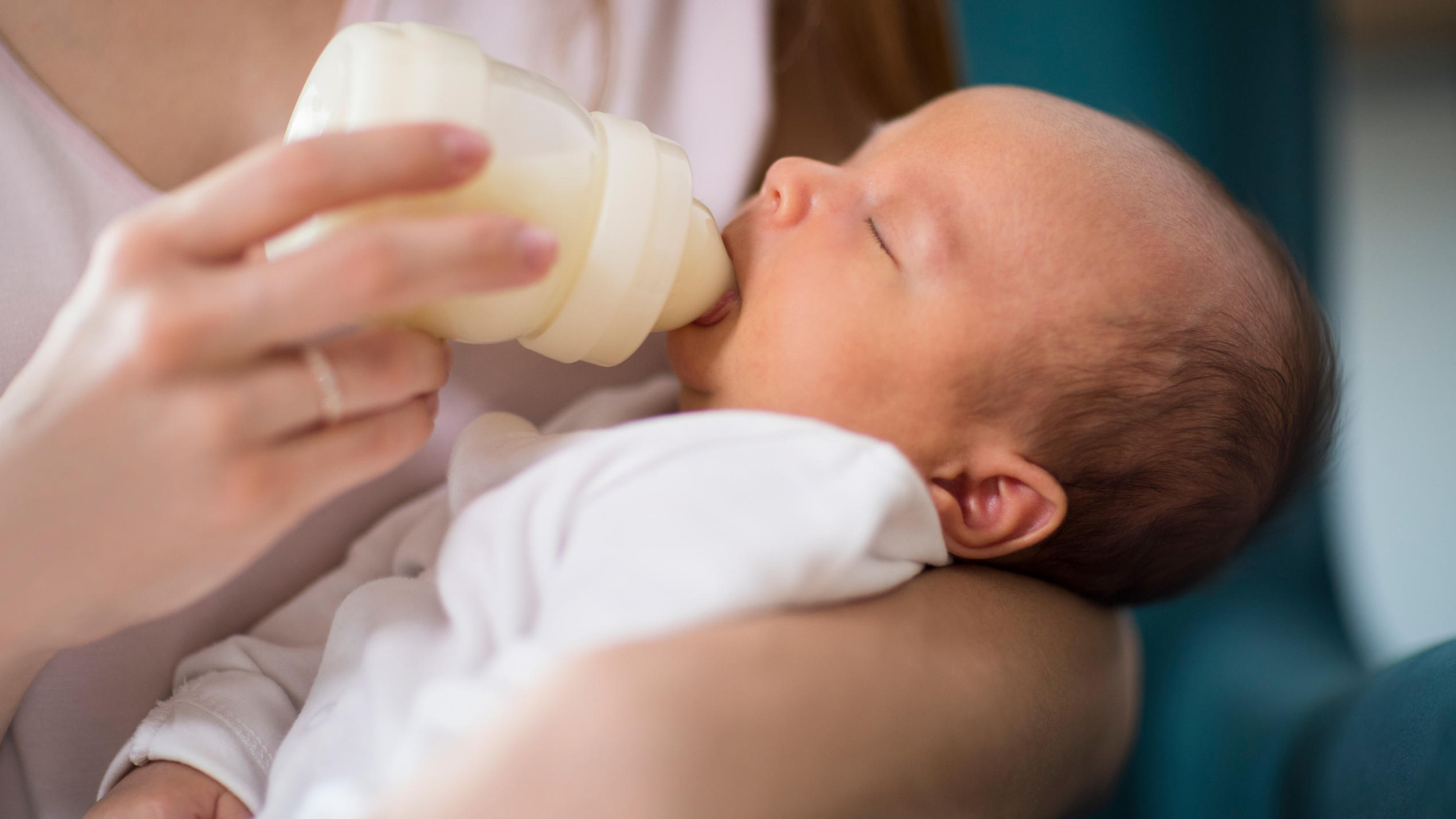 Cronobacter-Bakterien in Babynahrung entdeckt: Wie groß ist die Gefahr? Baby trinkt Milch aus der Flasche