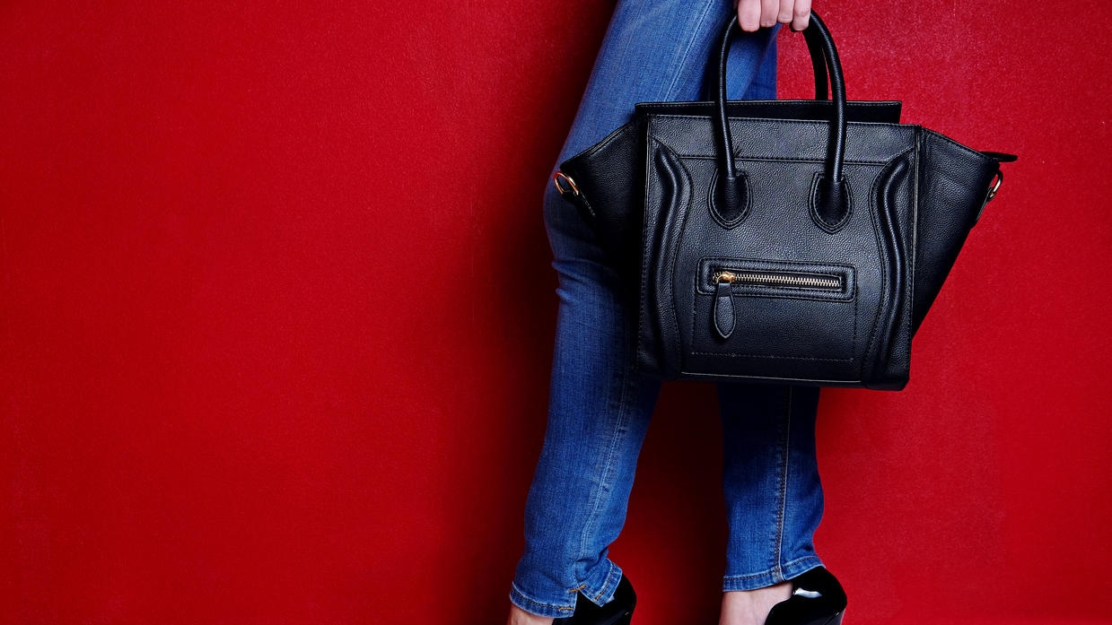 Fashion Lexikon: Nappaleder Frau posiert mit schwarzer Ledertasche