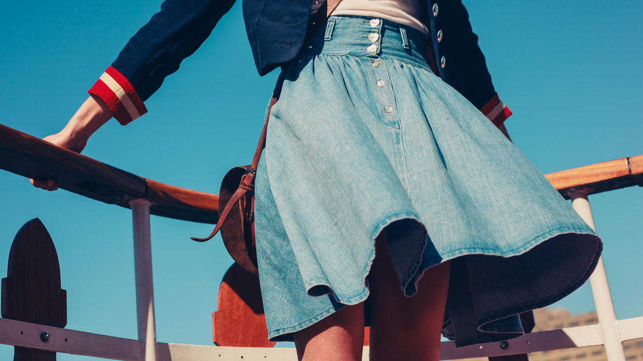Fashion Lexikon: Glockenrock Junge Frau trägt einen Glockenrock aus Denim