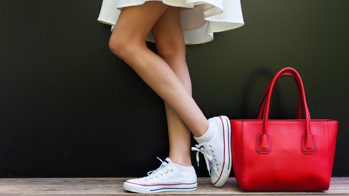 Fashion Lexikon: Sneaker Weiße Sneaker neben roter Handtasche