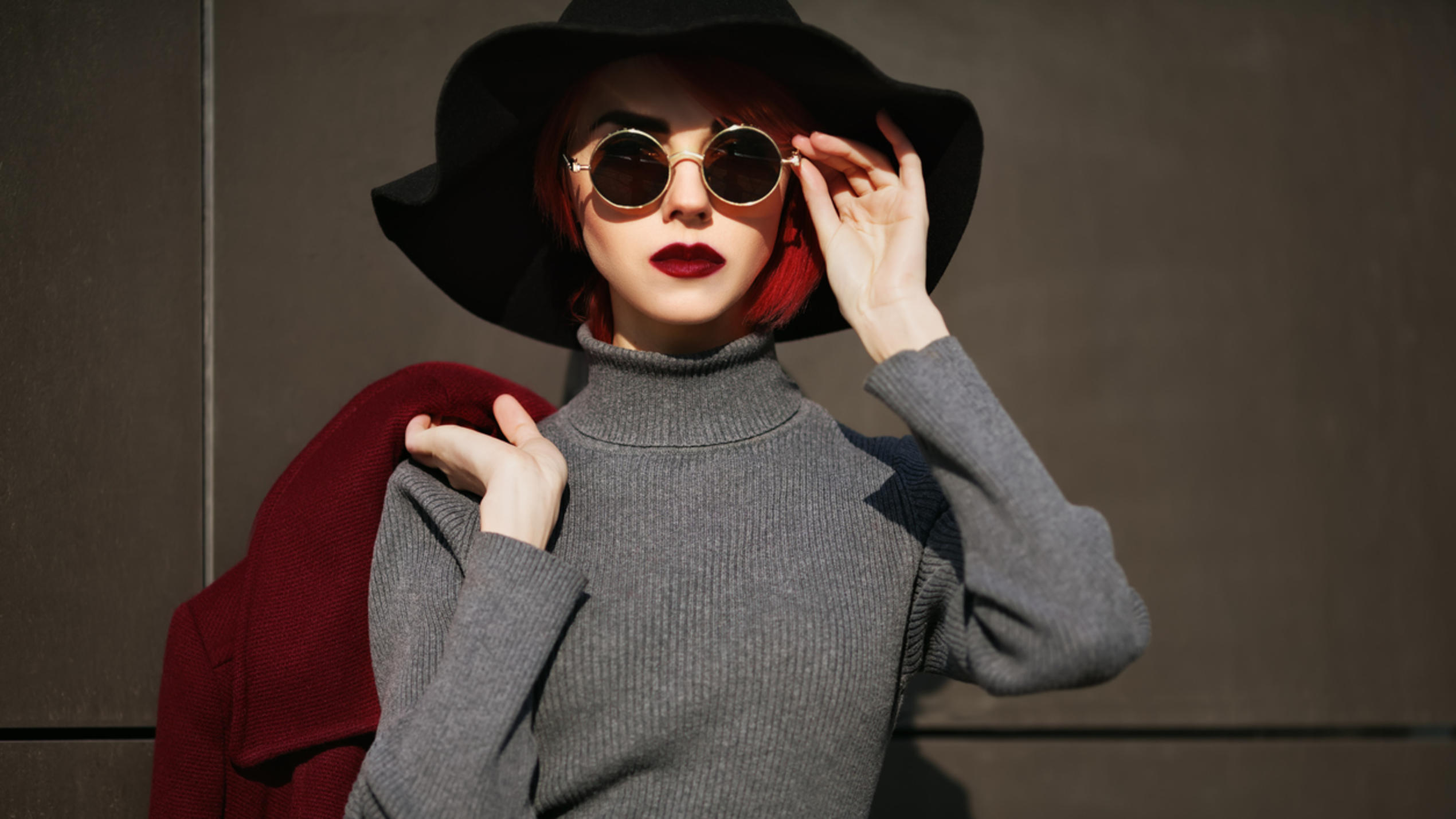 Fashion Lexikon: Turtleneck Frau mit Sonnenbrille trägt grauen Pullover mit Turtleneck