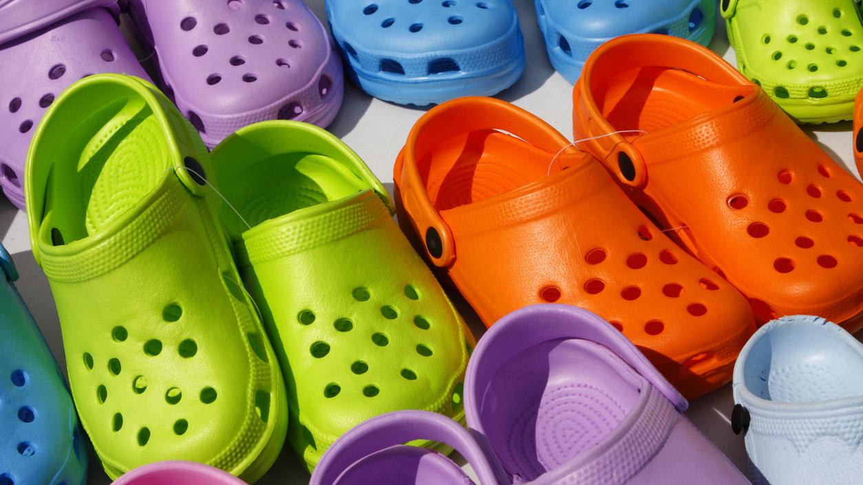 Fashion Lexikon: Crocs Hier sind mehrere Crocs in knalligen Farben zu sehen.