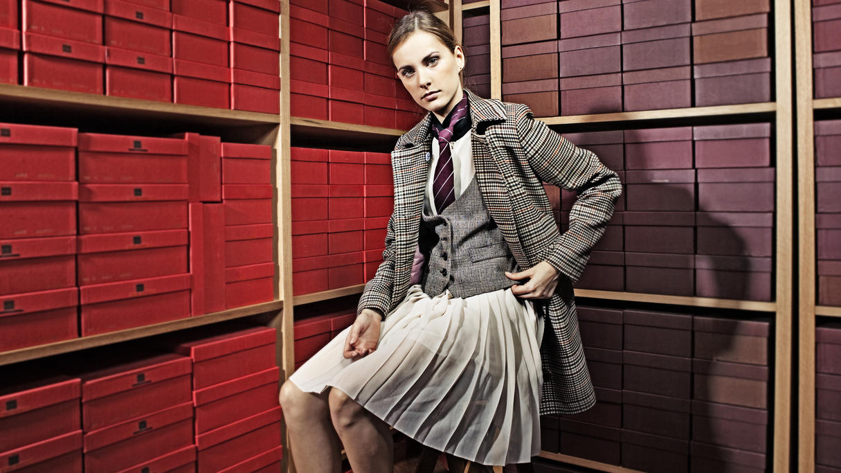 Fashion Lexikon: Donegal Tweed Junge Frau sitzt auf einem Hocker und trägt Kleidung aus Donegal Tweed.