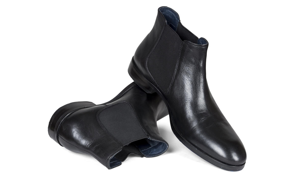 Fashion Lexikon: Chelsea Boots Schwarze Chelsea Boots auf weißem Hintergrund platziert