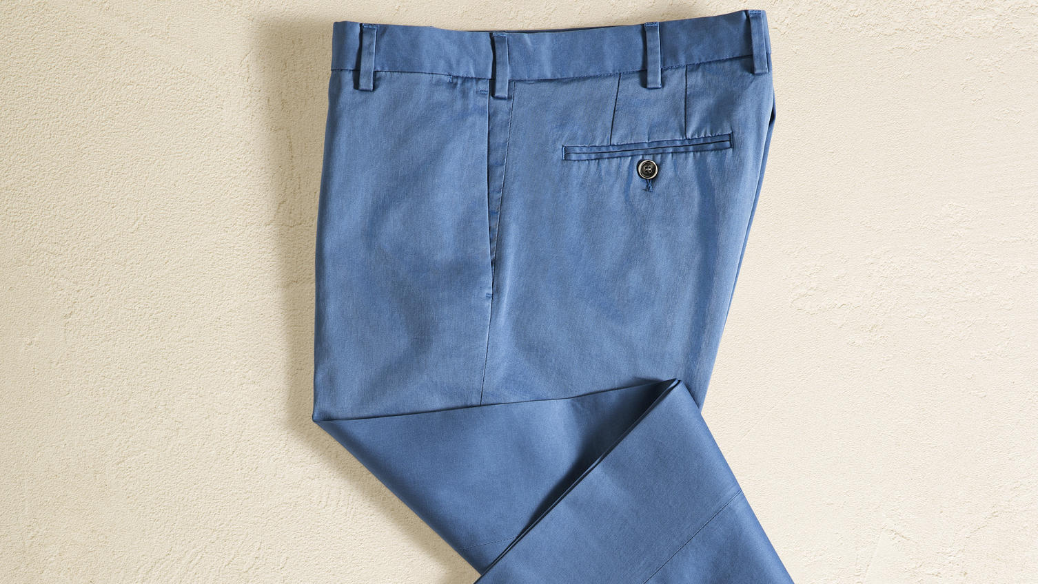 Fashion Lexikon: Chino Blaue Chino isoliert auf beigem Hintergrund