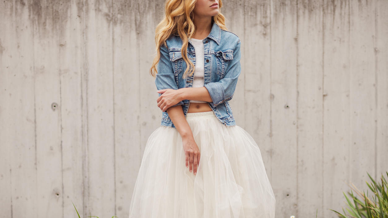 Fashion Lexikon: Tüll Junges Mädchen mit Jeansjacke und weißem Rock aus Tüll