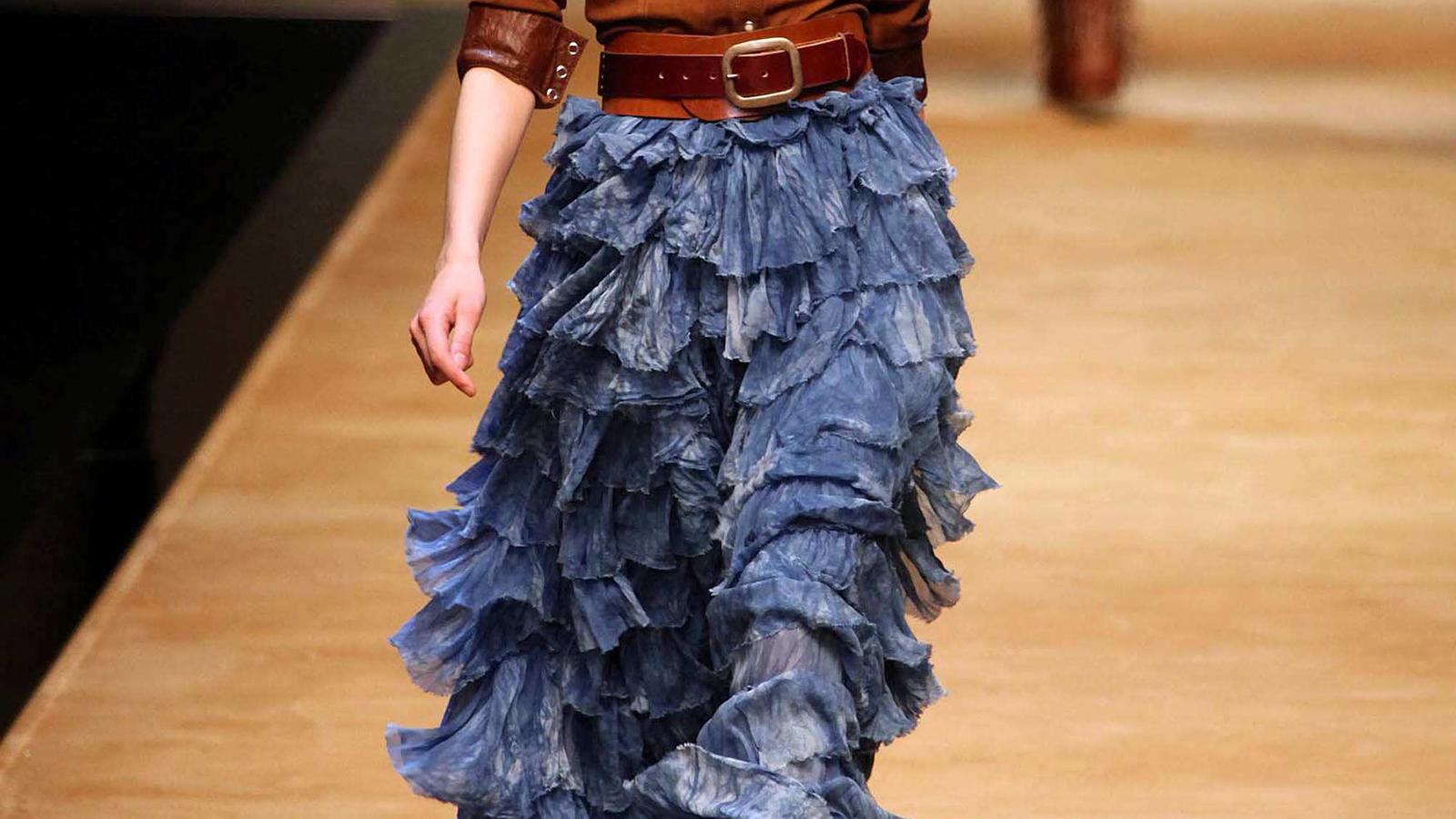 Fashion Lexikon: Volant Model trägt einen Rock mit blauen Volants