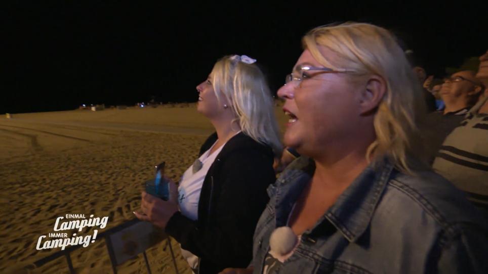 Mutter & Tochter genießen das Feuerwerk am Strand Mutter & Tochter genießen das Feuerwerk am Strand