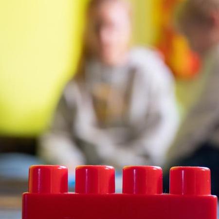 Eine Praktikantin liest an einem Sozialen Tag einer Hilfsorganisation Kindern in einer Kita vor. Foto: Sebastian Gollnow/dpa/Symbolbild
