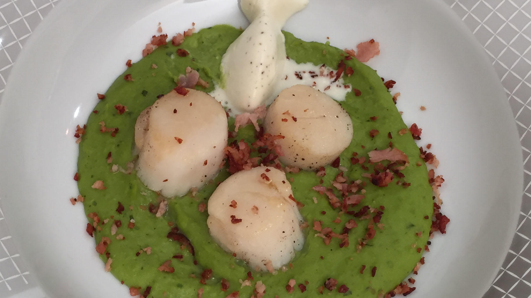 In Speck gebratene Jakobsmuschel mit Zuckerschoten auf geminzter Erbsen ... In Speck gebratene Jakobsmuschel mit Zuckerschoten auf geminzter Erbsen ...