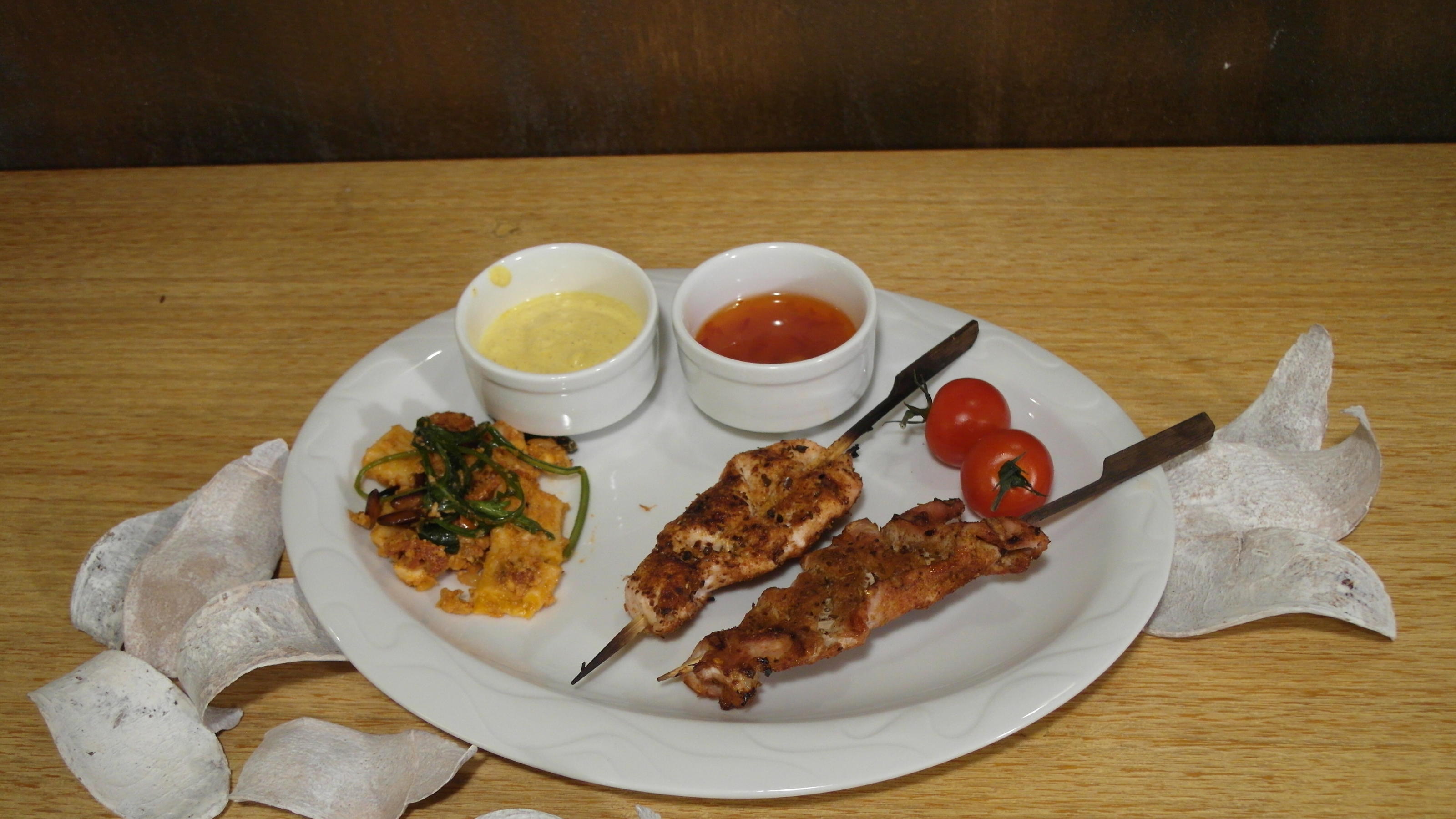 Thomas serviert als Vorspeise Saté-Spieße mit zweierlei Soßen