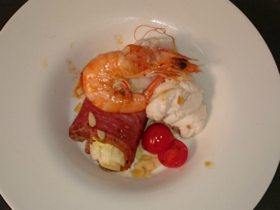 Seeteufel mit Riesengarnele auf im Speck ummantelten Romanasalat und Cocktailtomaten