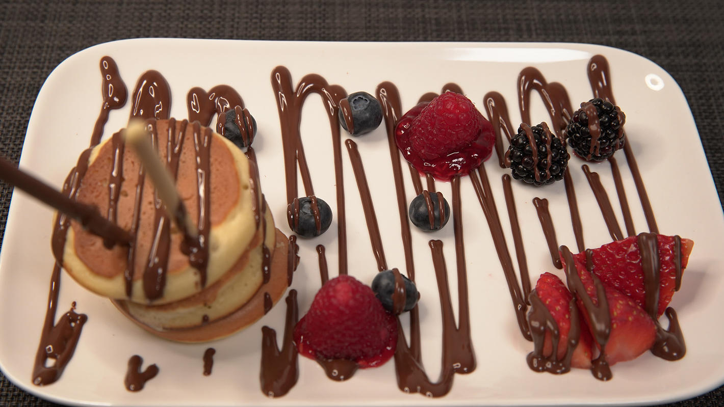 Das perfekte Dinner: Pancake am Stil auf einem Schoko- Früchtetraum ...