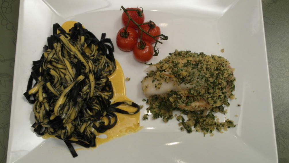 Marvins Hauptspeise: Fischknoten an schwarzen Bandnudeln auf einer ...