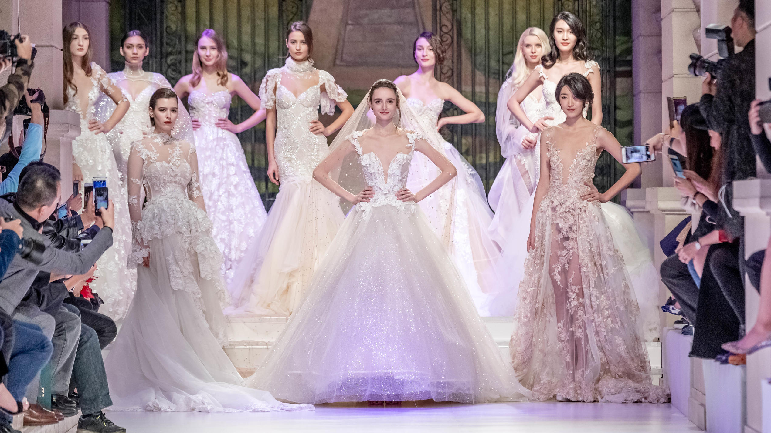 Mehrere Models präsentieren Haute Couture-Brautkleider auf einem Laufsteg. 