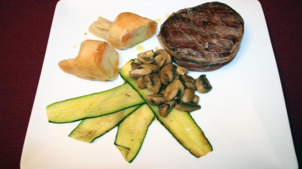 Bisonfilet im Speckmantel auf gebratenen Pfifferlingen und Zucchini an Kartoffel-Bonbons