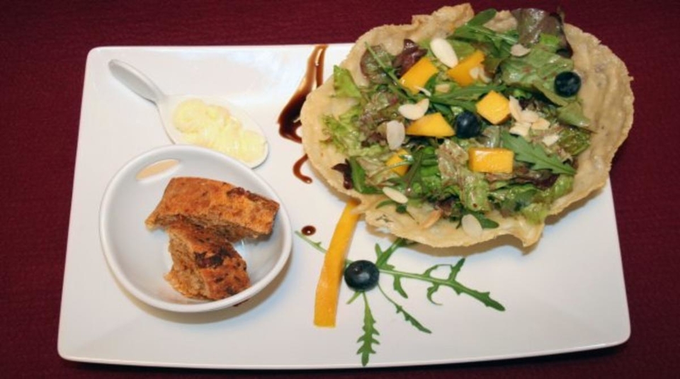 Mango mit gemischtem Salat im Parmesankörbchen an Blaubeeressig
