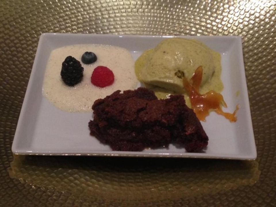 Pistazieneis mit Schokoküchlein an Beeren auf Vanilleschaum