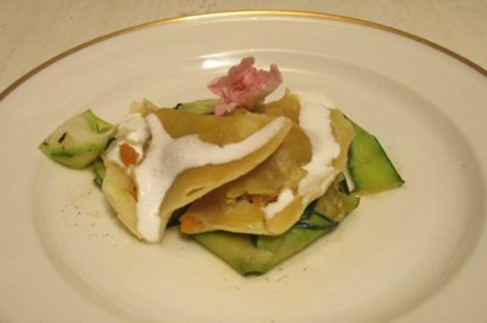 Wolfsbarschravioli auf Carpaccio von Babyzucchini, mit Trüffelöl und Parmesanschaum