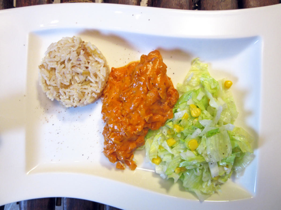 Hähnchenfilet nach westafrikanischer Art mit Zwiebelreis und Salat