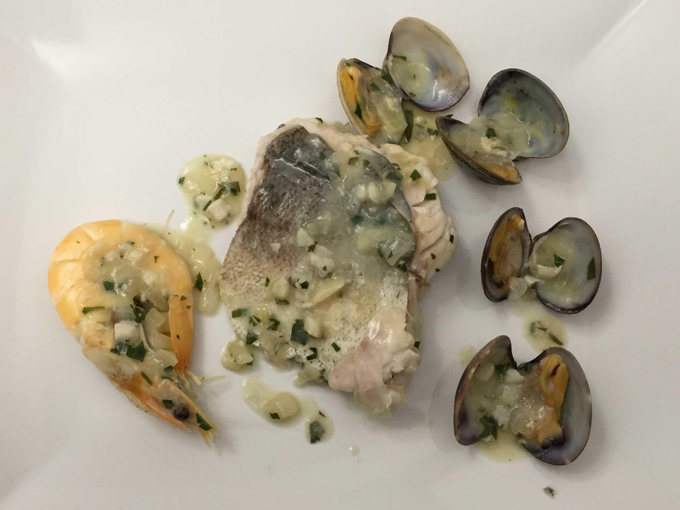 Seehechtfilet mit Meeresfrüchten in einer Petersiliensoße