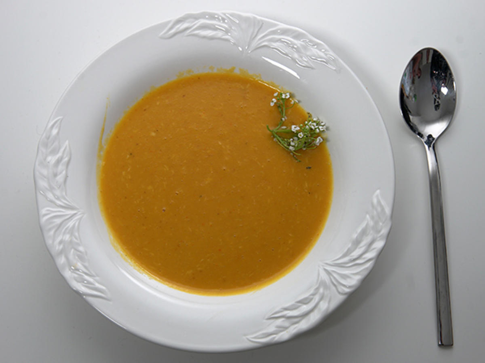 Kürbissuppe mit Garnelen hängend an Zitronengras