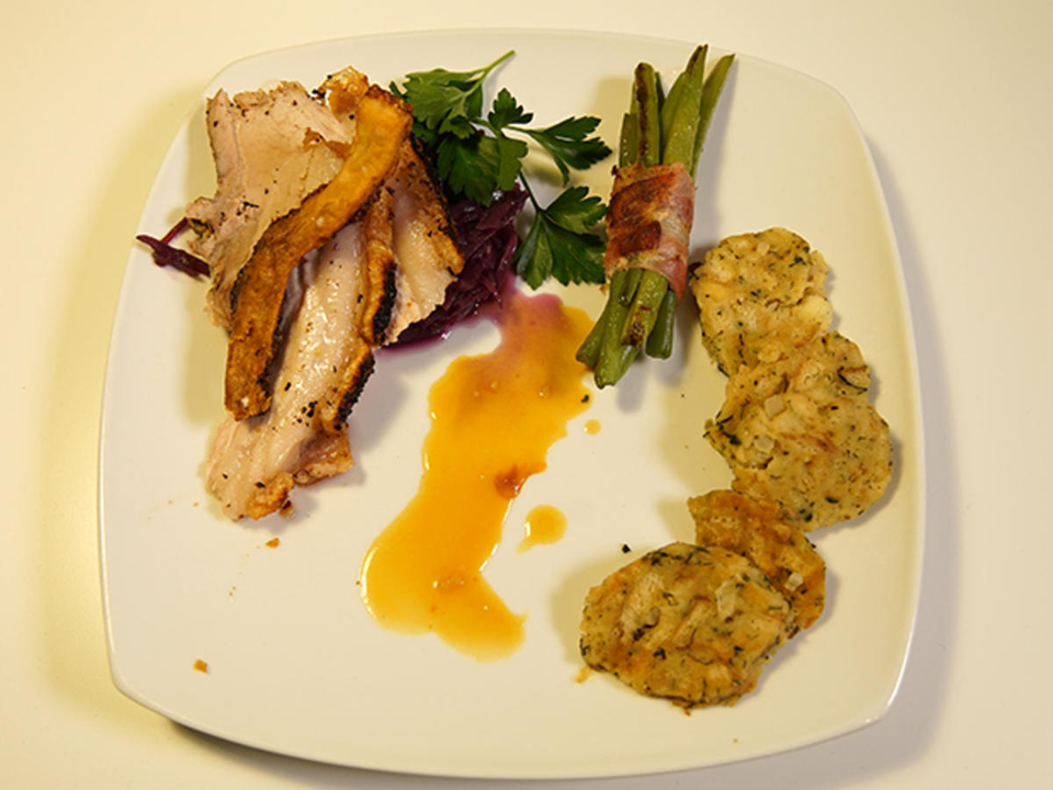 Krustenbraten mit Semmelknödel auf Rotkraut, Bohnen und Speck