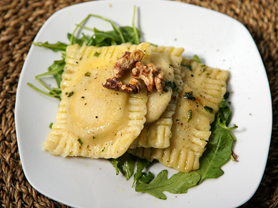 Frischkäse-Steinpilz-Ravioli, geschwenkt in Bärlauchbutter auf Rucolabett