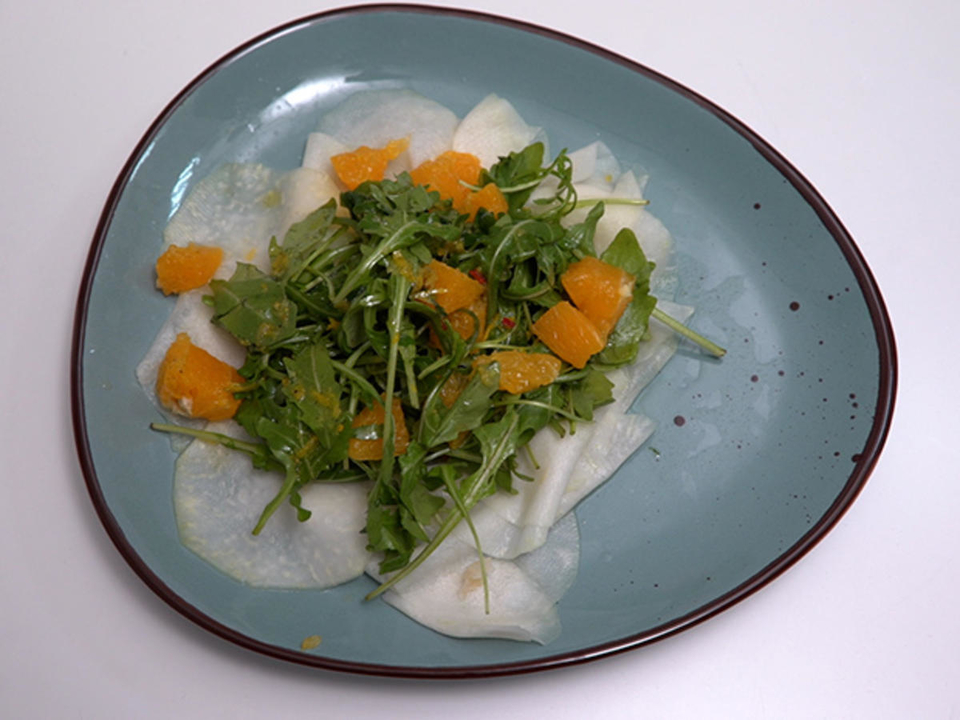 Carpaccio von dem Kohlrabi in Symbiose mit zitrischer Vinaigrette, Rucola und Orangenfile