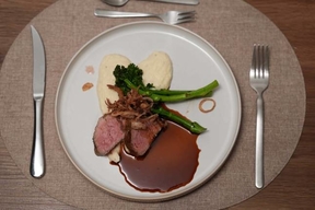 Rosa gebratenes Kalbsfilet mit sautiertem Brokkolini, Selleriepüree, Röstschalotten und Kalbsjus