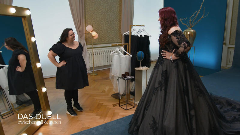 Marion schlüpft in eine dunkle Tüllrobe