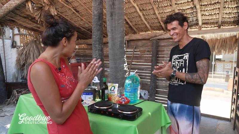 Gisele steht zwischen zwei Männern